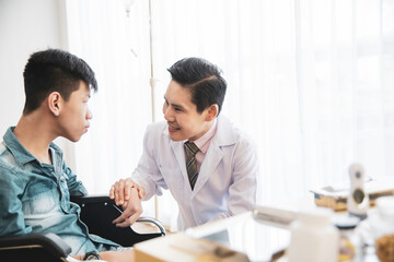 Fototapeta premium Asian doctor consulting and encourage disability young patient wheelchair person at hospital,