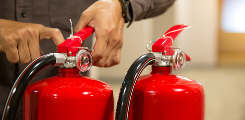 Fire fighter pull the safty pin of fire extinguishers tank in the building concepts of fire prevention emergency safety rescue of fire services and training.