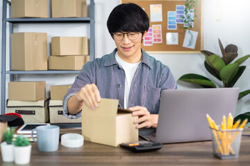 Asian business man working in a cardboard box prepares delivery box for customer