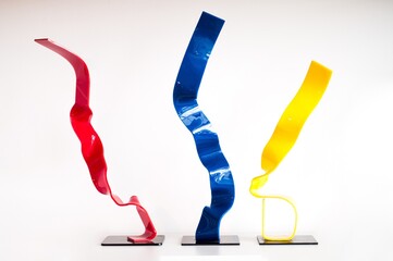 Red, blue and yellow ribbons flying in the air with a white background