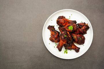 Barbecue roasted chicken legs, wings, drumsticks on plate, isolated. Copy space.