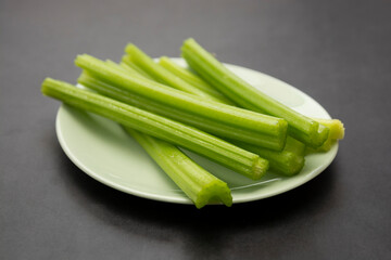 Detox food. Fresh celery sticks on gray background.