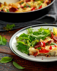 Chorizo Frittata with salad on black and white plate. healthy morning breakfast food