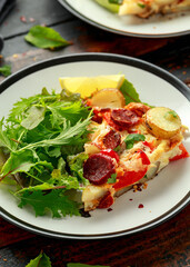 Chorizo Frittata with salad on black and white plate. healthy morning breakfast food