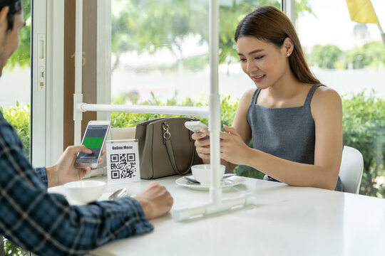 Asian customer scanning QR code for online menu un new normal restaurant - Powered by Adobe