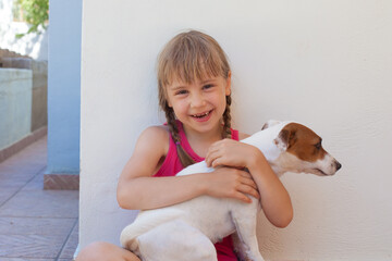 Child girl cuddling with dog pet