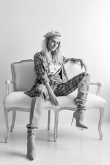 Fototapeta premium Beautiful blonde fashion woman in brow checked dress. Trendy young woman in shabby chic white interior.