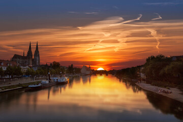 Fototapeta na wymiar Sonnenuntergang in Regensburg, Blick von der eisernen Brücke auf die steinerne Brücke mit tollen Wolken