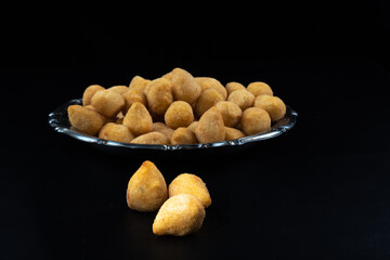 fried party snacks arranged on a stainless steel plate with black background