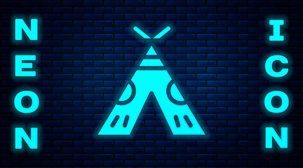 Glowing neon Traditional indian teepee or wigwam icon isolated on brick wall background. Indian tent.  Vector Illustration © Kostiantyn