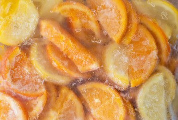 frozen lemon, orange, strawberry, kiwi in the refrigerator bag. fresh appetizing juice. frozen fruit for lemonade. fresh lemon oranges for summer.