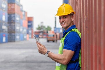 Smart creative foreman engineer man using digital tablet control loading containers box from cargo freight ship for import export. Logistic, Transportation, import and export concept. with copy space