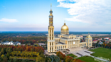 Naklejka premium Sanctuary and Basilica of Our Lady of Licheń in village Lichen. The biggest church in Poland, one of the largest in the World. Famous Catholic pilgrimage site. Aerial panorama in fall. Sunset light
