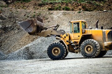 Close up details of wheel loader with scoop working on construction site. Heavy duty bulldozer working