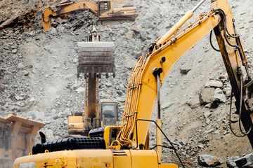 Industrial machinery on highway construction site, heavy duty excavator breaking granite mountain rocks