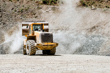 Wheel loader machine loading rocks in the open-mine, iron ore mining. © aboutmomentsimages