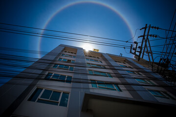 Amazing natural phenomena. Sun halo in Thailand or the sun with a rainbow on a tall building.
