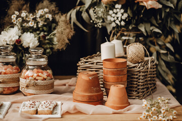 Candy bar. White wedding cake decorated by flowers standing of festive table with deserts, strawberry tartlet and cupcakes. Wedding. Reception Tartlets