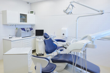 An interior of a dental office with white and blue furniture. Dentist’s office.