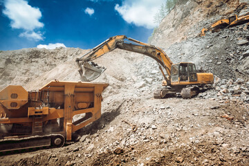 Mining industry - industrial excavator loading rocks and gravel into machinery © aboutmomentsimages