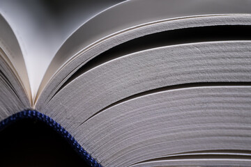 Right side of an open book with blue cover with narrow depth of field