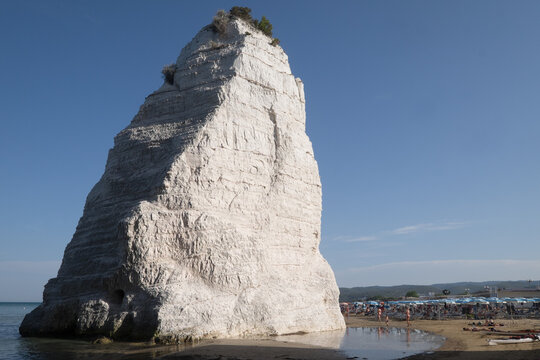 The famous rock tooth Pizzomuno on the sandy beach of Vieste in Gargano in Italy
