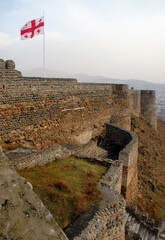 Gori Fortress with georgian flag. Gori town, Georgia, Caucasus.
