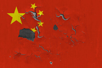 China flag close up old, damaged and dirty on wall peeling off paint to see inside surface. Vintage National Concept.