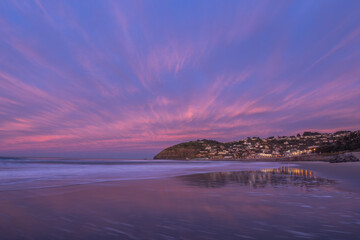 Beautiful sunrise of old jetty piles at St. Clair Beach in Dunedin, New Zealand.
