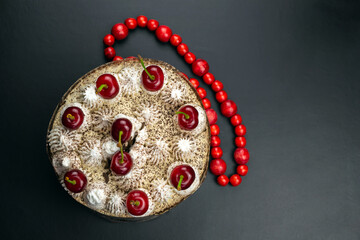 Tiramisu cake decorated with cherries, red beads