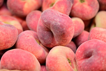 A large photo of peach fruits on a tray in a store, ready to sell fruit