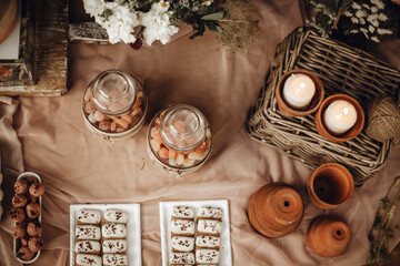 Candy bar. White wedding cake decorated by flowers standing of festive table with deserts, strawberry tartlet and cupcakes. Wedding. Reception Tartlets