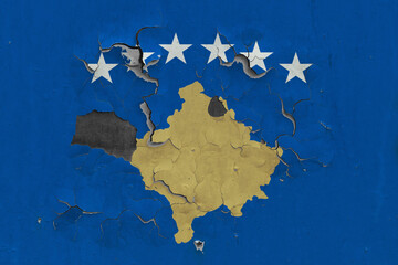 Kosovo flag close up old, damaged and dirty on wall peeling off paint to see inside surface. Vintage National Concept.