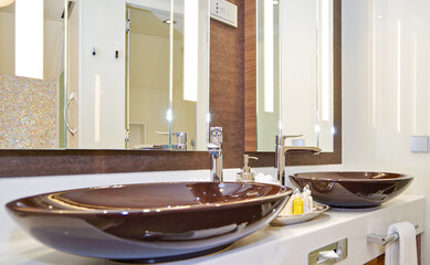 Elegant and modern design bathroom with double vanity and brown porcelain sinks  in clean style in...