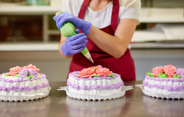 A pastry chef makes flowers from cream to decorate cakes.