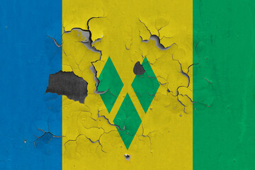 Saint Vincent And The Grenadines flag close up old, damaged and dirty on wall peeling off paint to...