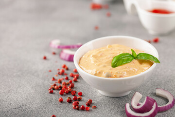 Thousand Islands sauce and ingredients - cucumbers, onions, paprika, ketchup and mayonnaise in bowls on the table. American cuisine, dip for burgers and meat.