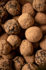 Pile of sweet truffle candies in cocoa powder close-up.