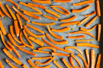 Fresh orange carrot sticks with pepper and olive oil ready for baking