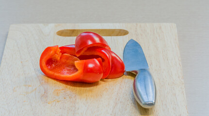 Slices of red paprika on a wooden cutting board