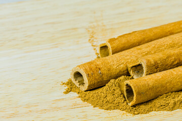Cinnamon sticks laying on cinnamon powder