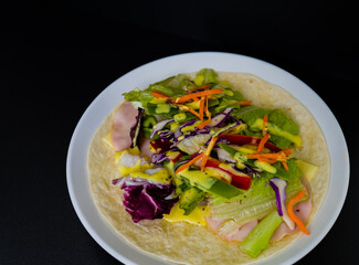 Ham, mozzarella cheese, and vegetables covered with honey mustard on flour tortilla