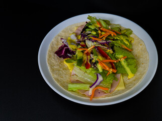 Ham, mozzarella cheese, and vegetables covered with honey mustard on flour tortilla