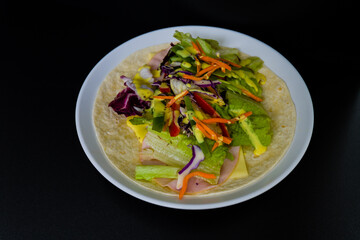 Ham, mozzarella cheese, and vegetables covered with honey mustard on flour tortilla