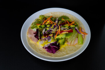 Ham, mozzarella cheese, and vegetables covered with honey mustard on flour tortilla