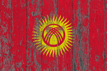 Kyrgyzstan flag on grunge scratched wooden surface. National vintage background. Old wooden table scratched flag surface.