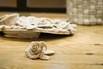 Beautiful rose shaped pastry on wooden table under soft lights with other pastry and background blurred slightly