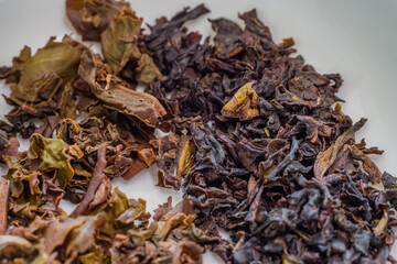 Dry tea leaves in white dish