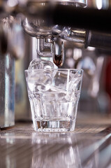 ice cubes in glass on espresso machine..