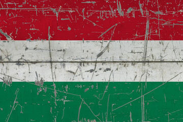 Hungary flag painted on cracked dirty surface. National pattern on vintage style surface. Scratched and weathered concept.